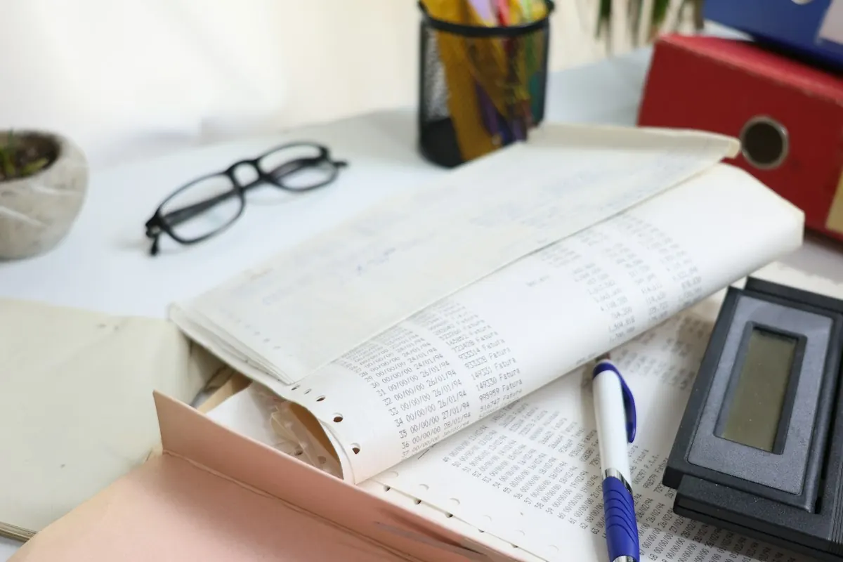أوراق وقلم وآلة حاسبة على مكتب